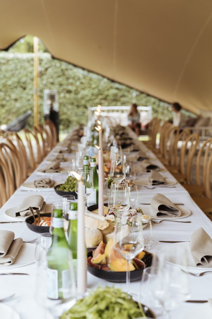 Stijlvol gedekte lange tafel met kaarsen en linnen servetten voor een feestdiner